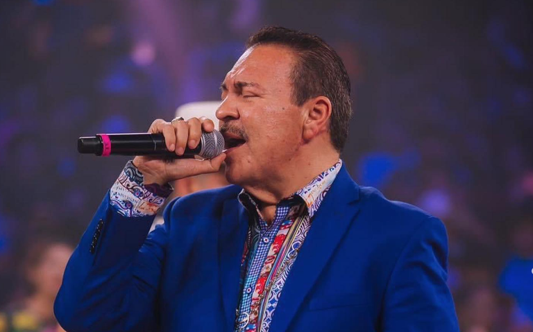 Julio Preciado llora mientras está cantando en el escenario.